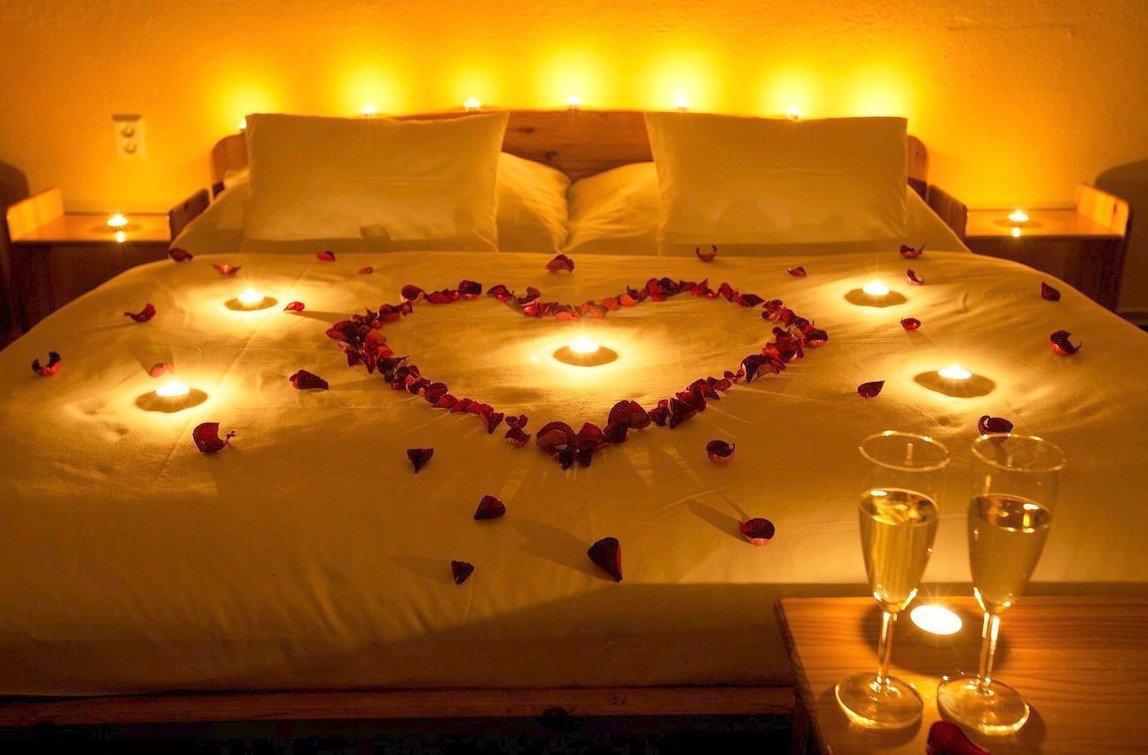 Брачная постель. Романтичная спальня. Постель в лепестках роз и свечи. Романтика свечи лепестки роз. Кровать с лепестками роз и свечами.